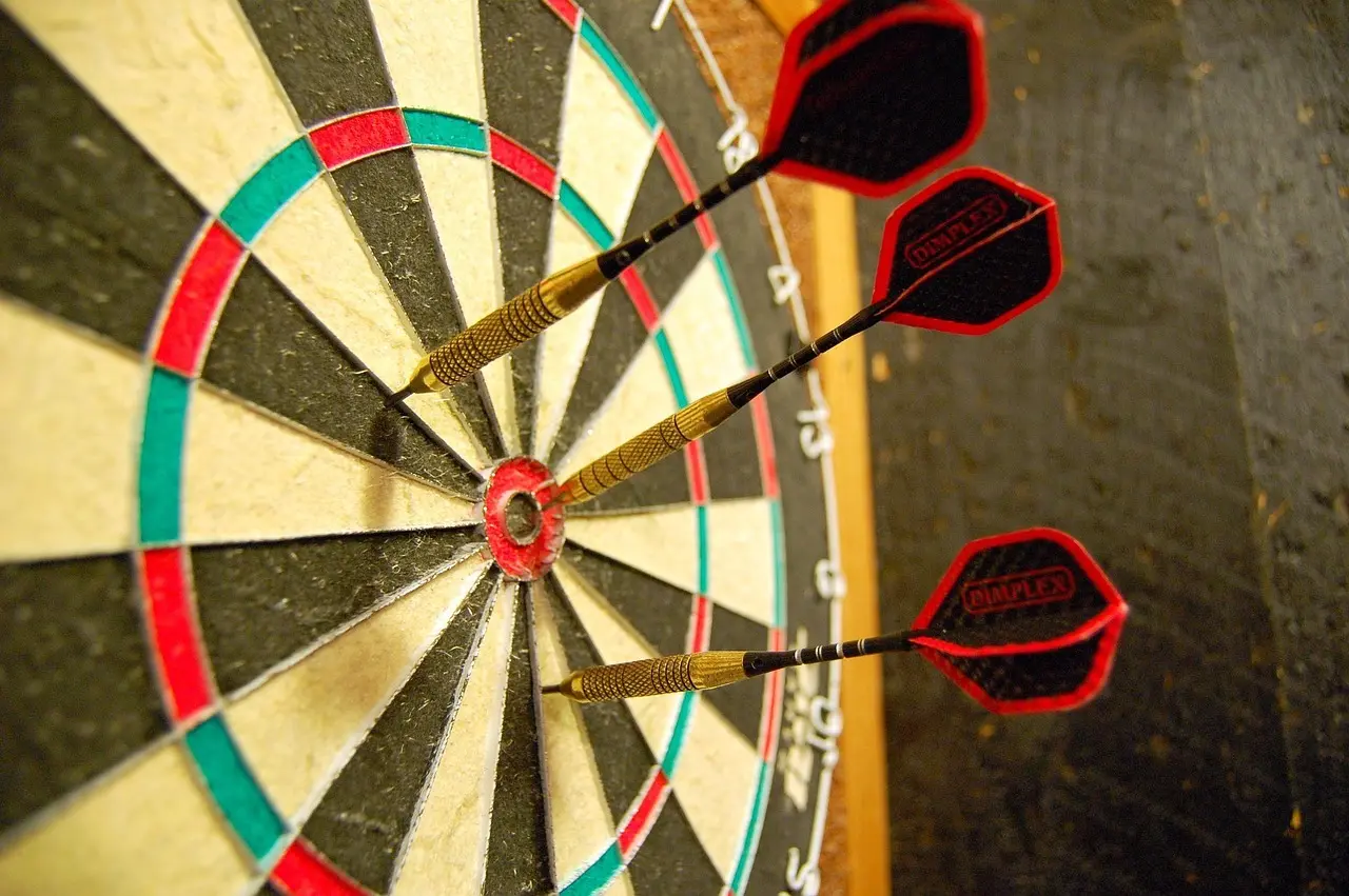 Dartbræt med tre pile tæt på bullseye